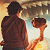 Pixelated static image of two figures standing side-by-side facing a cityscape at sunset, with warm tones and visible dithering.