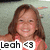 A young girl with long brown hair wearing a coral sleeveless top smiles broadly, with text "Leah <3" overlaid on the lower left.
