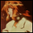 Pixelated anime-style character with long orange hair and light-colored clothing against a dark background, next to stylized text on a black