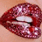 Pixelated close-up of lips with glittery red lipstick and a white tooth, next to red text on a yellow background.