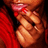 Pixelated close-up of a person's face with closed eyes, wearing a red garment and a red headband with a white stripe, against a dark background.