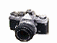 A black and silver camera icon with a lens, showing sequential animation frames where a white X appears and disappears on the camera body.