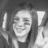 A grayscale pixelated image of a person with closed eyes and a slight smile, holding two vertical objects resembling candles or sticks.