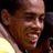 Pixelated close-up of a person's face with visible facial features and partial clothing, displayed as a static 48x48 icon on a dark background.