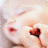 Pixelated close-up of a face with red eyes and a dark red mouth, holding a small object against a light background.