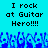 Pixelated blue background with black text reading "I rock at Guitar Hero!!!!" and a of pixelated hands raised in the foreground