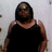 Pixelated image of a person with dark hair wearing a black sleeveless top against a light background.