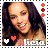 Alicia Keys smiling with dark hair, wearing a light-colored top, with heart symbols and text below her face.
