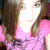 Pixelated close-up of a person with long brown hair wearing a pink top, face partially obscured by bright lighting.