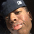 A person wearing a dark cap with white logo, showing three sequential facial expressions against black background.