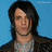 Pixelated image of a person with long dark hair against a blue background, with cyan text blocks on black and gray