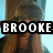 A pixelated image of a person with long brown hair wearing a dark top and fur hat, with the name 'BROOKE' overlaid in bold white text on a black background.