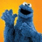 Blue cookie monster character with raised hand against orange background, blue pixelated text on black side reads WHERE DA COOKIES AT????