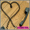 A heart-shaped arrangement of black telephone handsets on a wooden floor, with a pink banner reading "I LOVE YOU" at the bottom.