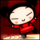 Animated character in red traditional outfit with black hair buns, performing drumming actions