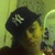 A person wearing a black cap with white 'NY' text holds an object near their mouth against a yellowish background.