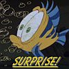 A cartoon fish with blue and yellow stripes, green eyes, and a white underbelly holds a large white object with two green spots, set against a dark background with faint circular patterns and the word 'SURPRISE!' in yellow text.
