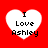 Four identical white heart shapes on a solid red background, each containing black text reading "I Love Ashley" in pixelated font.
