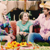 A pixelated static image shows three people seated together, with visible clothing colors and a blurred background.
