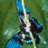 Pixelated static image of a figure in blue and black attire holding a glowing sword against a green background.