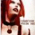 Pixelated image of a person with long red hair wearing dark clothing and light-colored pants, standing against a bright background.