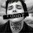 Pixelated grayscale image of a person with closed eyes, dark hair, and a black band across the mouth displaying 'LOVE YOU' text on chest.