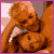 Pixelated static image of two figures in close embrace with orange-brown color palette and purple border, likely from a television show character icon set.