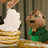 Animated scene with a cartoon character in green clothing holding a stack of pancakes, background shows wooden and another figure's legs