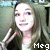 Pixelated static image of a person with long brown hair wearing dark clothing, making a hand gesture near their face.