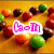 Pixelated image with a warm yellow-orange background featuring scattered round objects in red, green, and brown tones, with a central pink text overlay reading "Lol" on a white rectangular background.