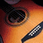 A close-up of a sunburst-finish acoustic guitar with visible soundhole and fretboard, featuring yellow text reading "billy!" in the lower-left corner.