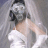 Pixelated static image of a figure with light skin tone wearing white clothing and dark hair, set against a muted gray background.