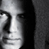 Static grayscale buddy icon featuring a stylized human face with high-contrast shading and pixelated edges, cropped to show partial facial features against a dark background.