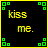 Pixelated text 'kiss me.' in yellow-green hues on black background with green square corner accents.