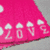 Animated pink icon with white cloud symbols and '20' text on a diagonal section, transitioning to a full view of a bright pink gerbera daisy against black background.