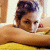 A pixelated image of a person with dark hair styled up, resting their head on an arm against a yellow surface, next to green text reading "Original Icons .com".