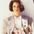 Pixelated image of a person with short brown hair wearing a white shirt and light-colored jacket against a plain background.
