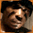 A 48x48 pixel buddy icon featuring a split composition with an orange border, showing a partial portrait of a person on the left and text elements in three quadrants against a gray background.