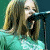 Animated contact sheet of Avril Lavigne performing with pixelated text overlays across five frames showing different angles and text variations.