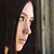 Pixelated close-up of a person's face in profile view against a dark background with vertical light strip on right.