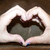 A pixelated heart-shaped icon with a dark central area and light outer edges, set against a brown background.