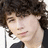 A pixelated image of a person with curly brown hair on the left, next to pink text 'i' and repeated 'love love love' on purple background.