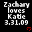 Black background displays repeated white text 'Zachary loves Katie 3.31.09' with red heart symbols, one in each 's right side