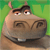 Pixelated cartoon hippopotamus face with brown skin, dark eyes, and a wide mouth showing one visible tooth against green background.