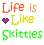 Pixelated text and heart symbols on a white background with a Skittles candy image, displaying 'Life Is Like Skittles' and 'Color Every Time'.