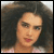 Static 50x50 pixel icon showing a close-up of a person with dark curly hair and light skin, rendered in low-resolution pixel art style with visible dithering.