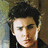 Pixelated close-up of a person with dark hair and light skin, wearing a black top against a blurred background.