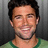 Pixelated image of a smiling man in a green shirt with dark hair against a gray background, with text overlays in some views.