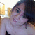 A person with dark hair and a black strapless top smiles in a of four showing slight head and eye position changes