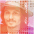 A pixelated image of a person wearing a light-colored cap and orange clothing, with a pinkish background and visible pixelation artifacts.
